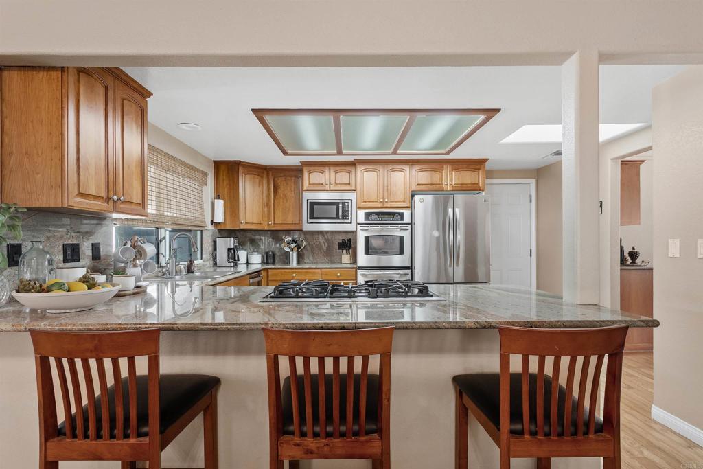 2614 Secret Lake Lane Fallbrook, CA 92028 - Photo 11 of 60 a kitchen with stainless steel appliances granite countertop a stove top oven a sink and dishwasher