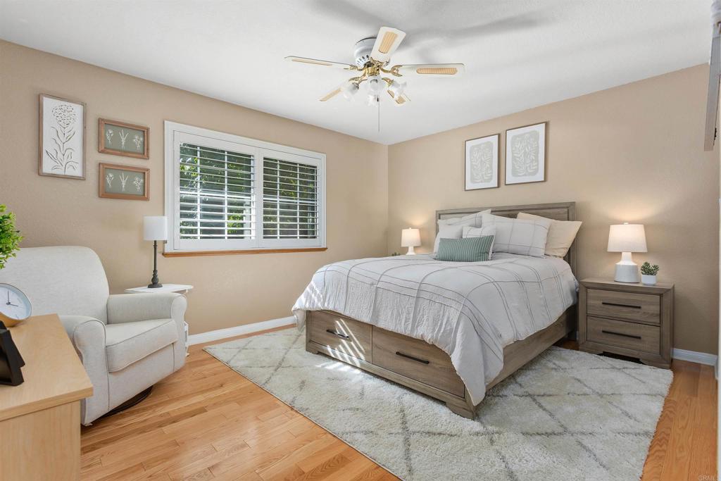 2614 Secret Lake Lane Fallbrook, CA 92028 - Photo 26 of 60 a spacious bedroom with a bed a couch and a window