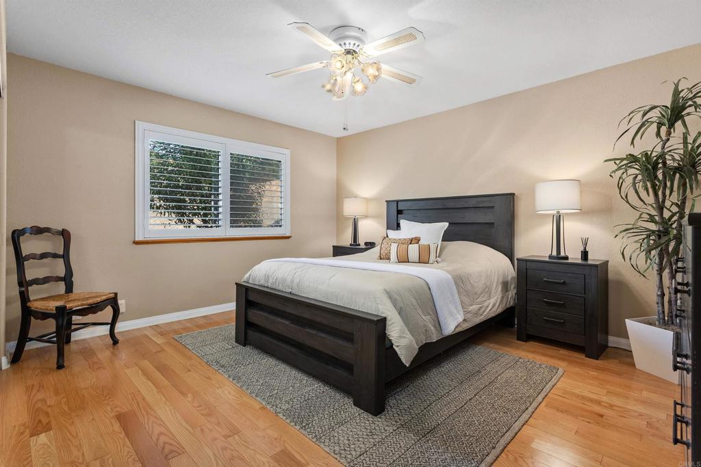 2614 Secret Lake Lane Fallbrook, CA 92028 - Photo 27 of 60 a bedroom with a bed and a chandelier