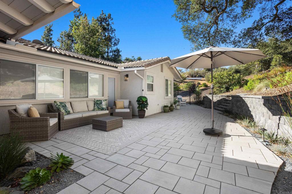 2614 Secret Lake Lane Fallbrook, CA 92028 - Photo 33 of 60 a view of a patio with couches table and chairs under an umbrella