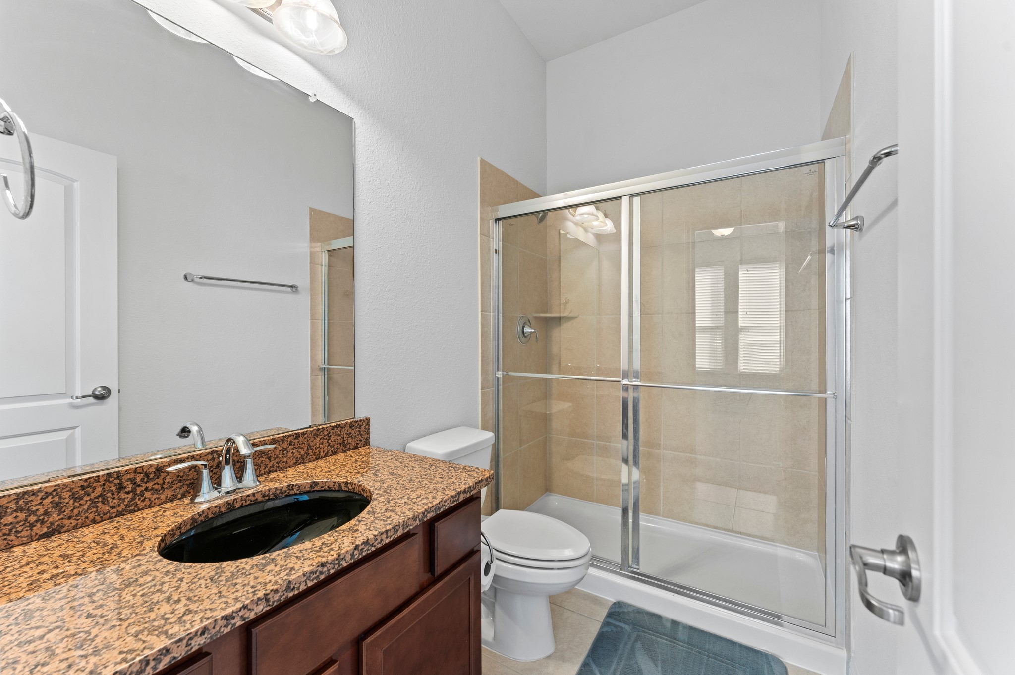 39 Tioga Place Tomball, TX 77375 - Photo 14 of 50 a bathroom with a granite countertop sink a toilet and shower