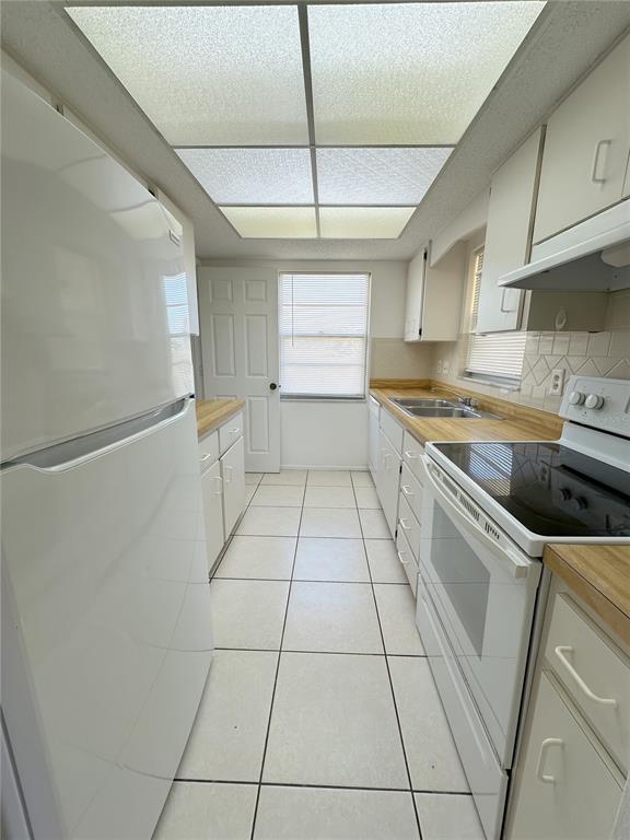 320 Boundary Boulevard, Unit A Rotonda West, FL 33947 - Photo 4 of 11 a kitchen with a cabinets and white appliances
