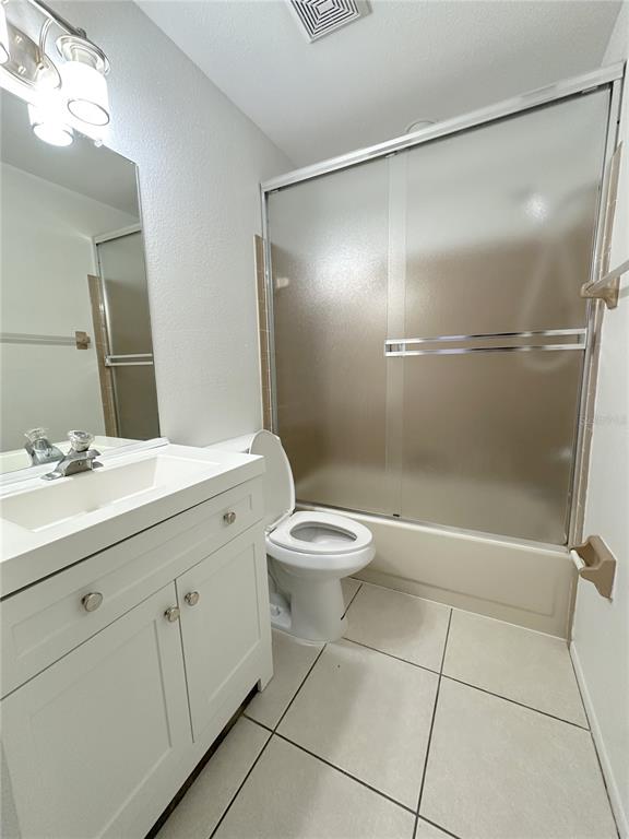 320 Boundary Boulevard, Unit A Rotonda West, FL 33947 - Photo 9 of 11 a bathroom with a granite countertop sink toilet a mirror and shower