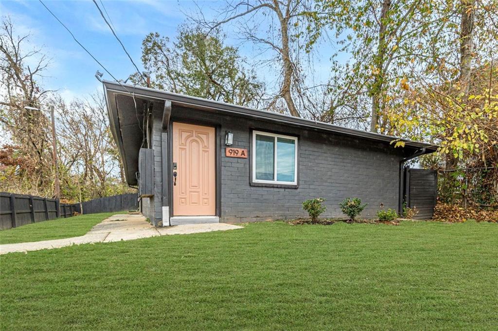 a backyard of a house with potted plants and large tree