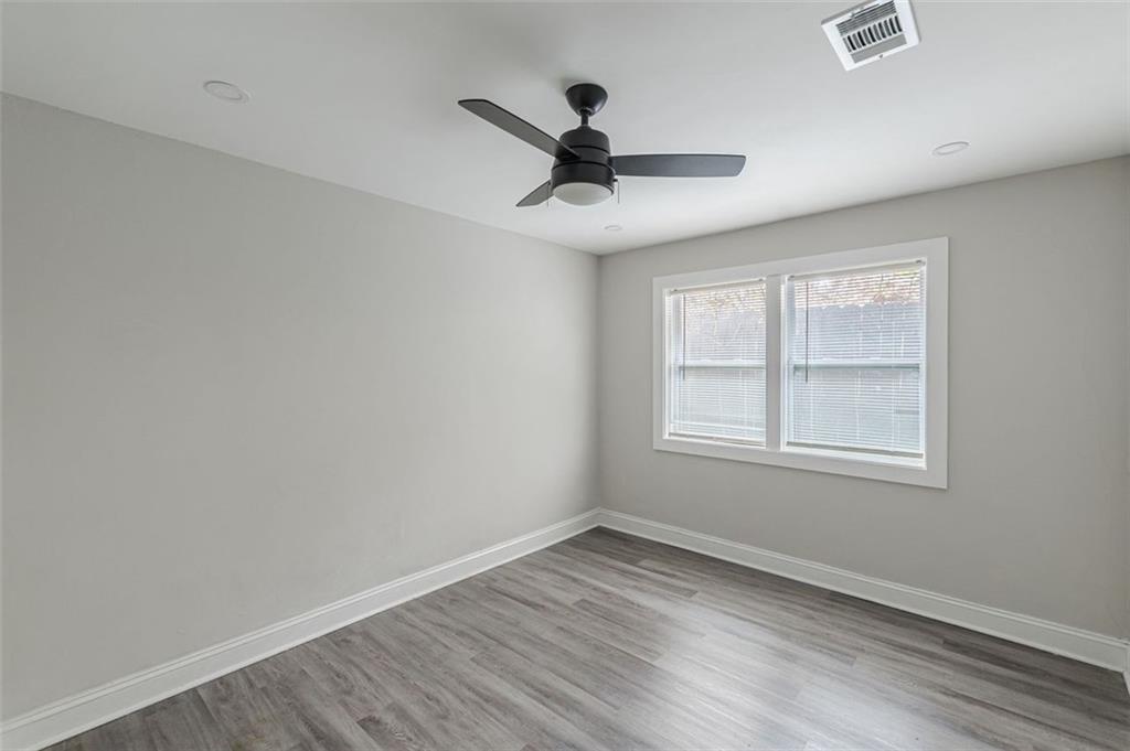 919 Hobson Street Southwest Atlanta, GA 30310 - Photo 14 of 24 an empty room with wooden floor ceiling fan and windows