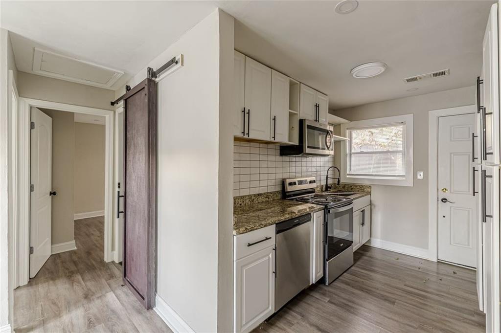 919 Hobson Street Southwest Atlanta, GA 30310 - Photo 3 of 24 a kitchen with stainless steel appliances granite countertop a stove and a refrigerator