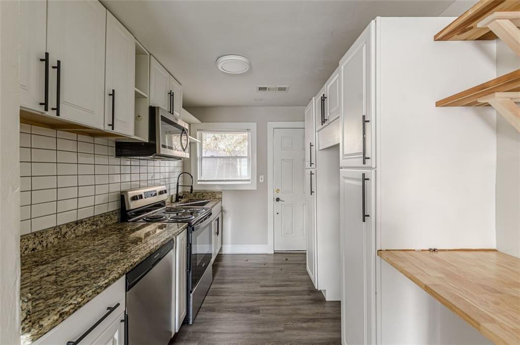 919 Hobson Street Southwest Atlanta, GA 30310 - Photo 4 of 24 a kitchen with stainless steel appliances granite countertop a stove and a refrigerator
