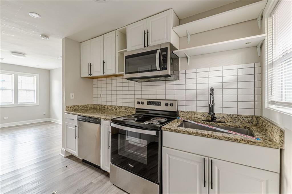 919 Hobson Street Southwest Atlanta, GA 30310 - Photo 6 of 24 a kitchen with granite countertop a stove and a sink