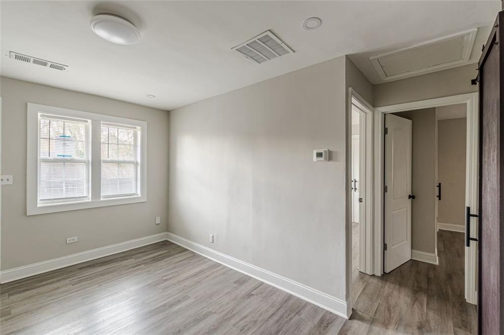 919 Hobson Street Southwest Atlanta, GA 30310 - Photo 7 of 24 a view of an empty room with wooden floor and a window