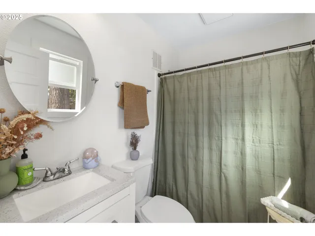 a bathroom with a double vanity sink a mirror a bathtub and shower