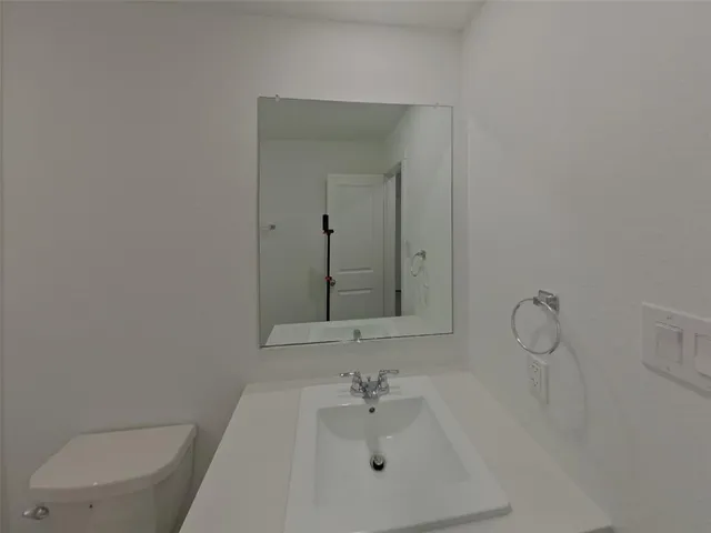 a bathroom with a sink a toilet and mirror
