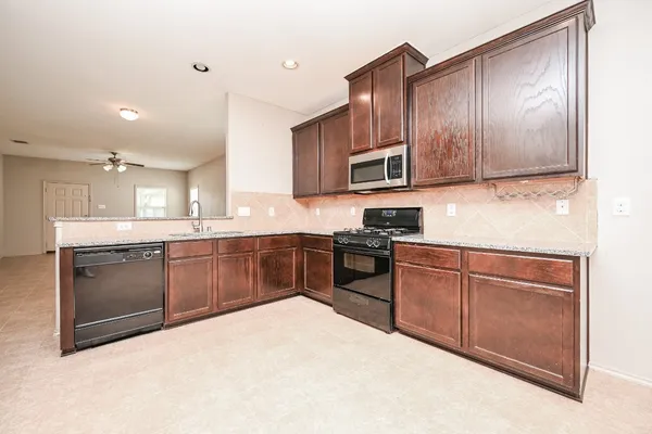a kitchen with granite countertop stainless steel appliances and wooden cabinets