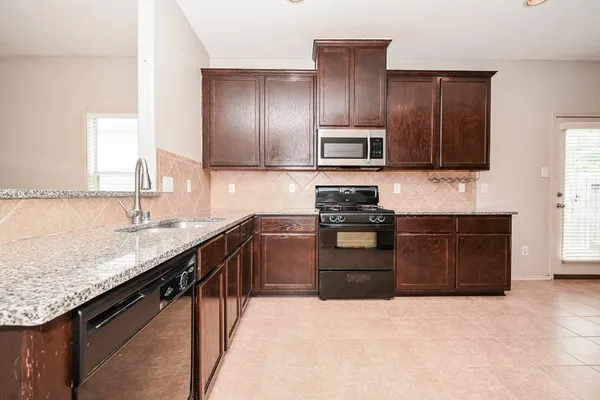 a kitchen with granite countertop cabinets stainless steel appliances and a counter space