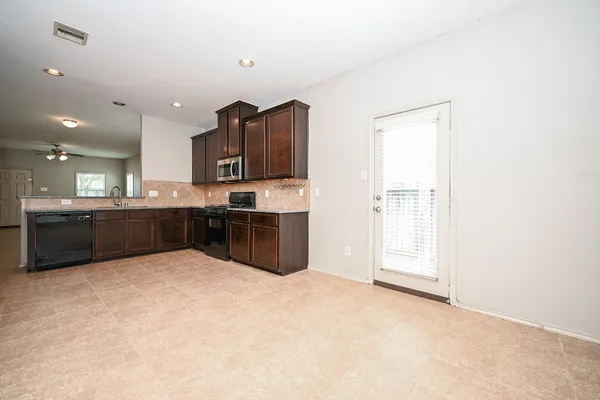 a view of kitchen with stainless steel appliances granite countertop a refrigerator and a sink