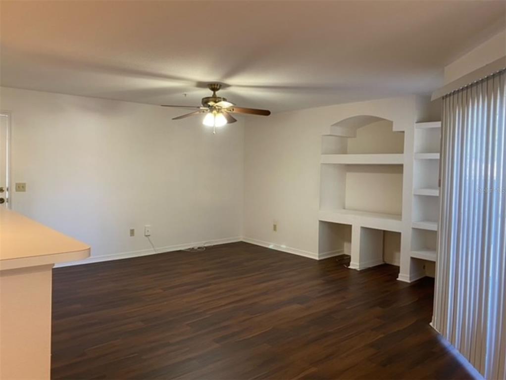 7300 Westpointe Boulevard, Unit 723 Orlando, FL 32835 - Photo 1 of 6 an empty room with wooden floor closet and windows