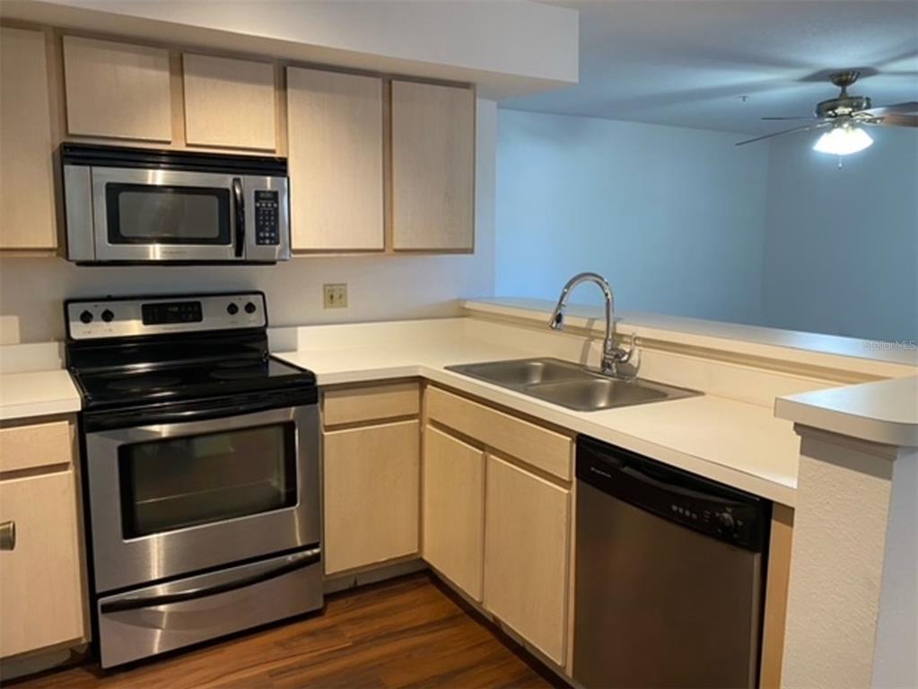 7300 Westpointe Boulevard, Unit 723 Orlando, FL 32835 - Photo 6 of 6 a kitchen with a sink stove and microwave