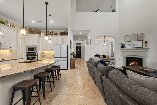 a kitchen with granite countertop a refrigerator stove and cabinets