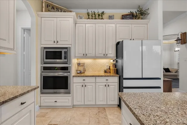 a view of living room kitchen with stainless steel appliances granite countertop furniture and a fireplace