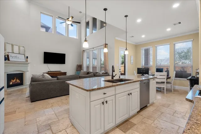 a kitchen with granite countertop sink window and chairs
