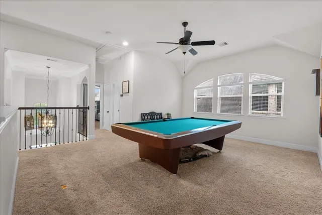 a room with pool table and windows