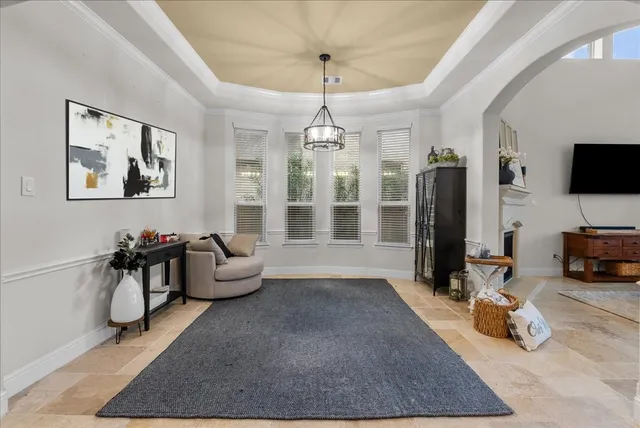 a living room with furniture a chandelier and a flat screen tv