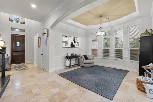 a living room with furniture a chandelier and a flat screen tv