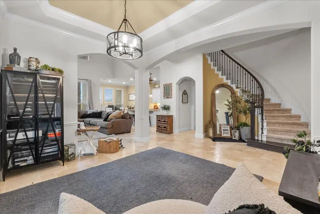 a living room with furniture a chandelier and a flat screen tv