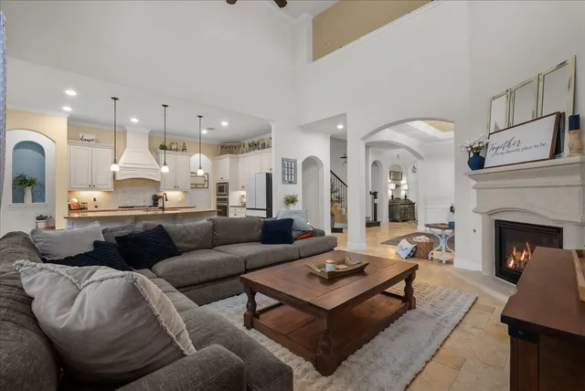 a living room with furniture a fireplace and kitchen view