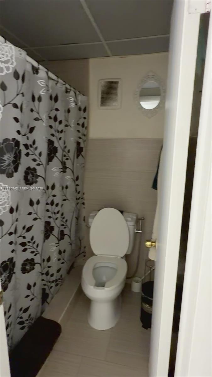 1225 West 35th Street, Unit 2A Hialeah, FL 33012 - Photo 2 of 3 a white toilet sitting next to a shower curtain