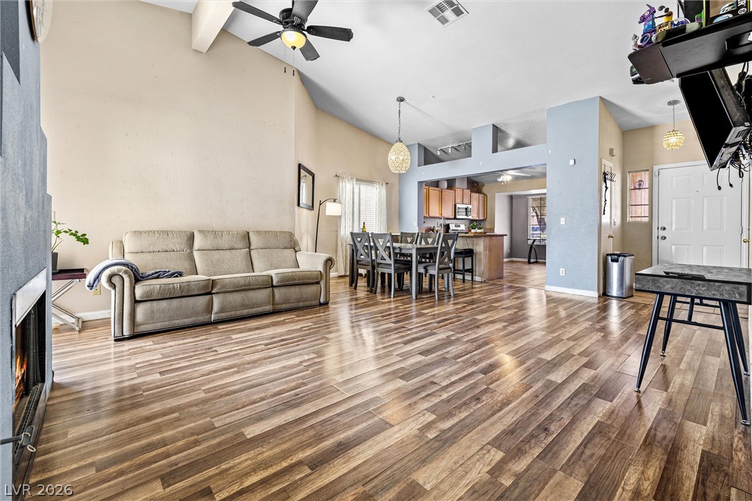 1624 Palmae Way Las Vegas, NV 89128 - Photo 18 of 18 This living area features rich wood flooring, high vaulted ceilings, and an open floorplan flowing into the dining and kitchen spaces.