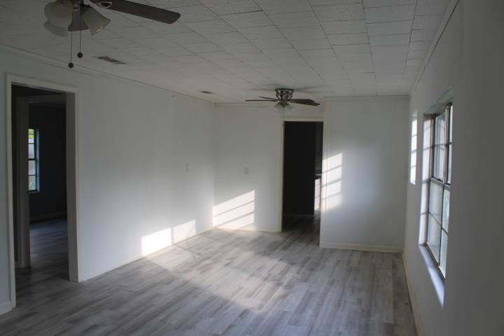 875 Woodrow Street Silsbee, TX 77656 - Photo 10 of 30 wooden floor in an empty room with a window