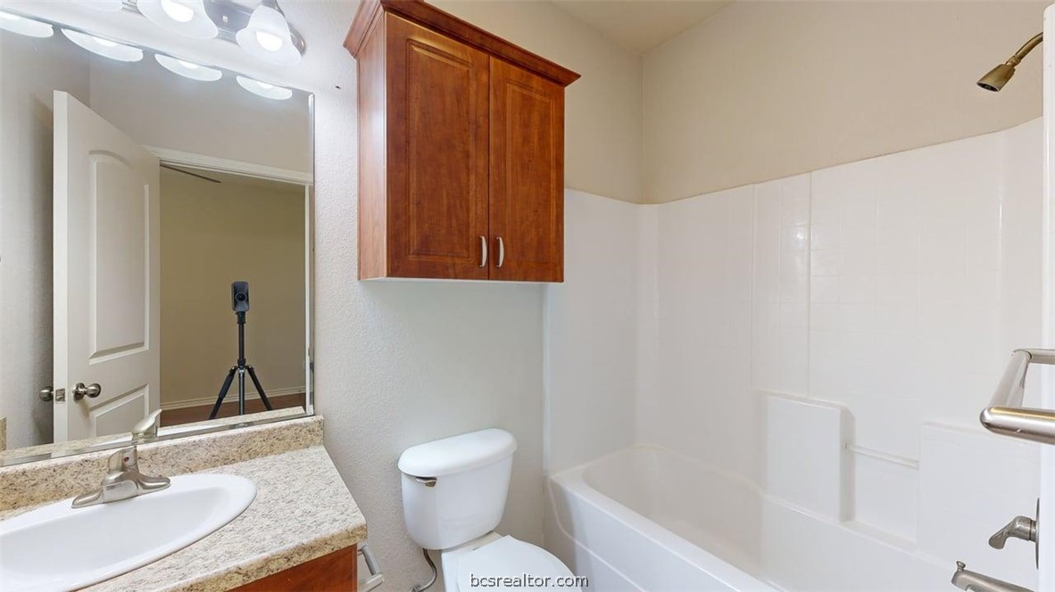 4453-4455 Reveille Road College Station, TX 77845 - Photo 11 of 37 a bathroom with a granite countertop sink toilet and shower