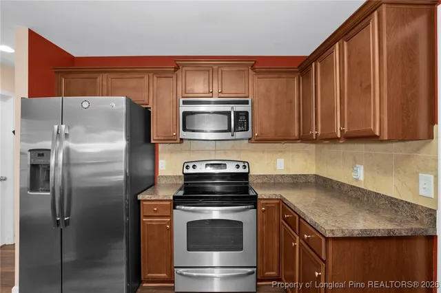 a kitchen with granite countertop a stove and a microwave