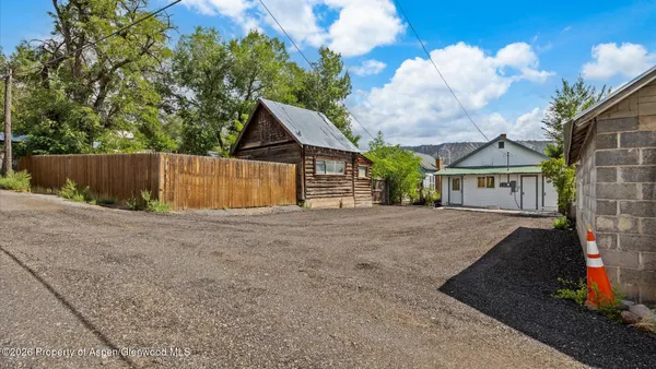 a view of a house with backyard and a tree
