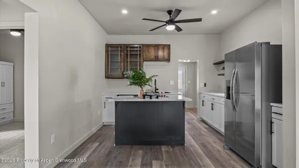a kitchen with stainless steel appliances a refrigerator and a hard wood floor