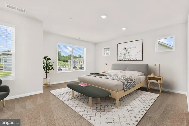 a spacious bedroom with a bed and wooden floor