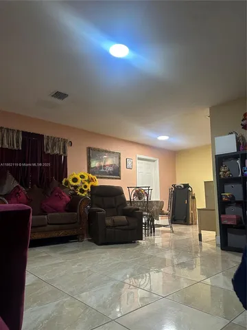 a living room with furniture a window and gym equipment