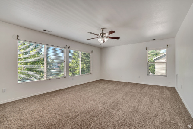 546 Wheatridge Road Tooele, UT 84074 - Photo 20 of 49 Spacious Master bedroom, featuring carpeting, multiple windows with blinds, a ceiling fan with integrated lighting, and neutral wall tones