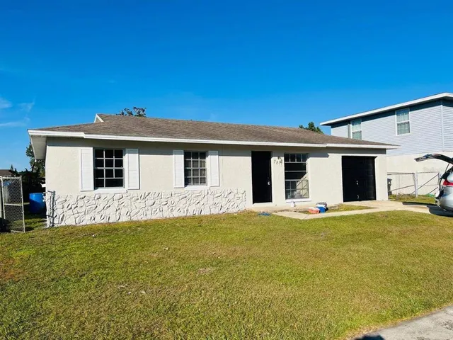 a front view of a house with a garden and yard