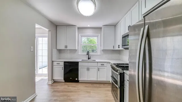 a kitchen with a sink cabinets and stainless steel appliances