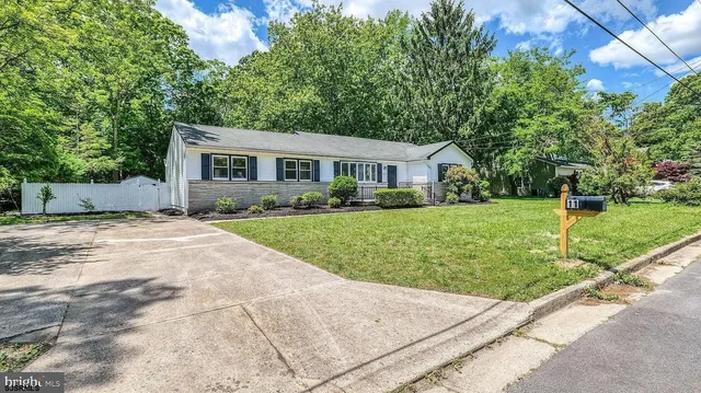 a view of a house with a yard and large trees