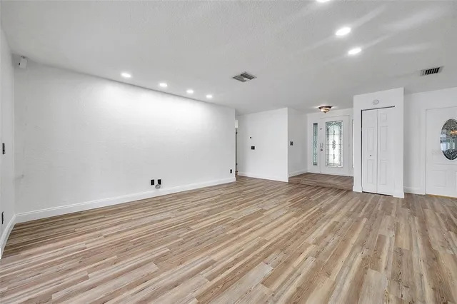 a kitchen with kitchen island stainless steel appliances a dining table chairs and wooden floor
