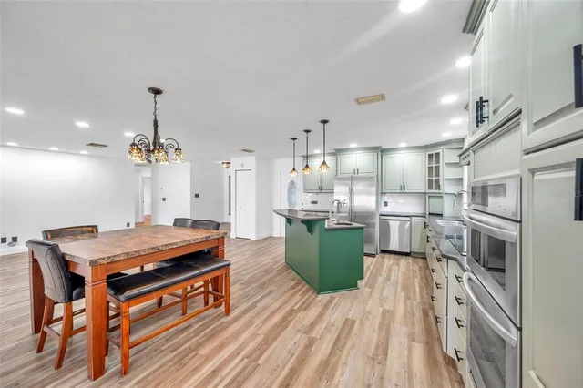 a kitchen with stainless steel appliances granite countertop a sink a stove and a refrigerator