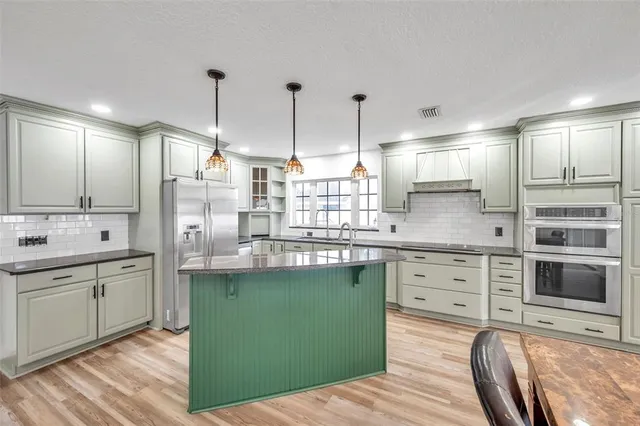 a kitchen with kitchen island a stove and a wooden floors