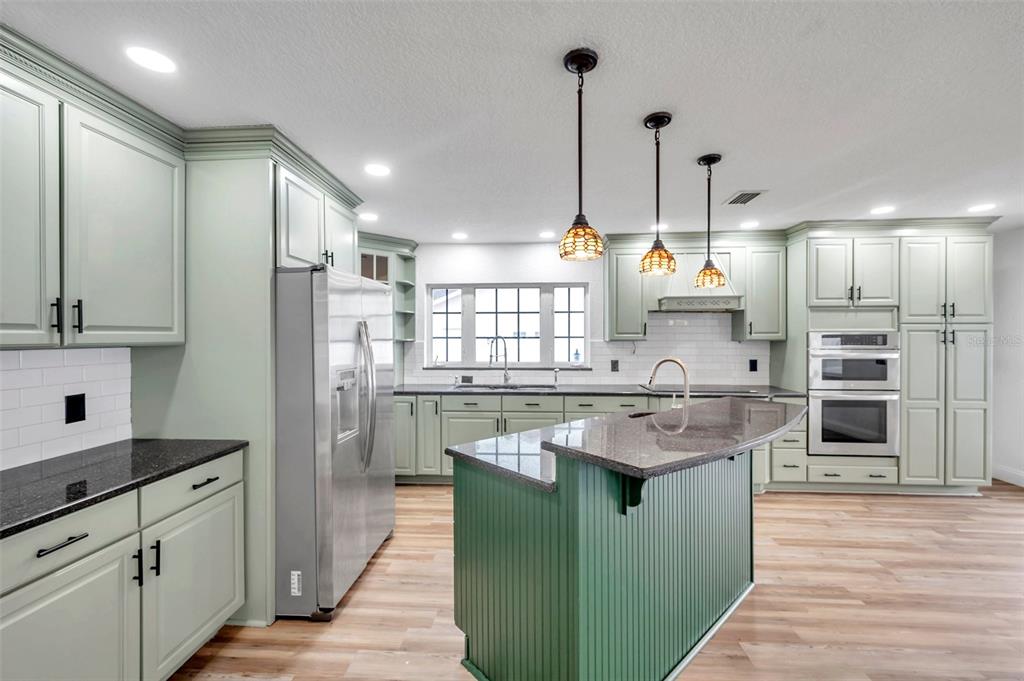1520 Windmill Pointe Road Palm Harbor, FL 34685 - Photo 19 of 64 a kitchen with stainless steel appliances granite countertop a sink a stove and a refrigerator