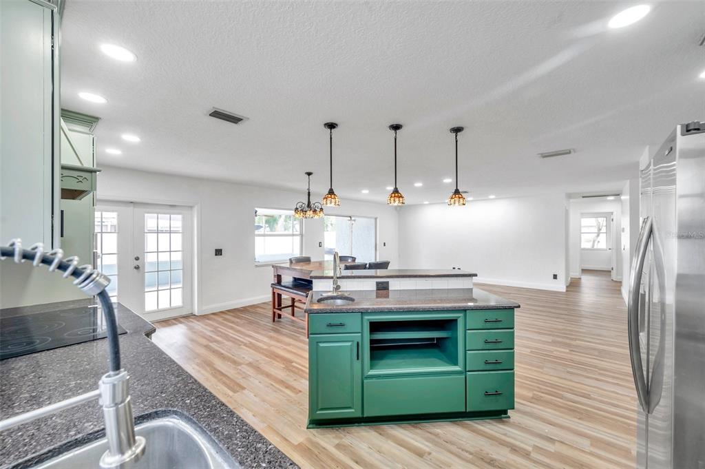 1520 Windmill Pointe Road Palm Harbor, FL 34685 - Photo 21 of 64 a kitchen with kitchen island a stove and a wooden floors