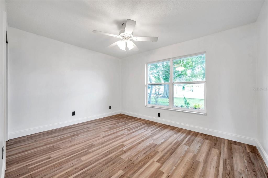 1520 Windmill Pointe Road Palm Harbor, FL 34685 - Photo 28 of 64 a view of an empty room with wooden floor and a window