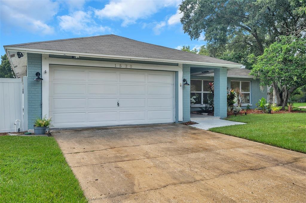 1520 Windmill Pointe Road Palm Harbor, FL 34685 - Photo 6 of 64 a front view of a house with a yard and garage