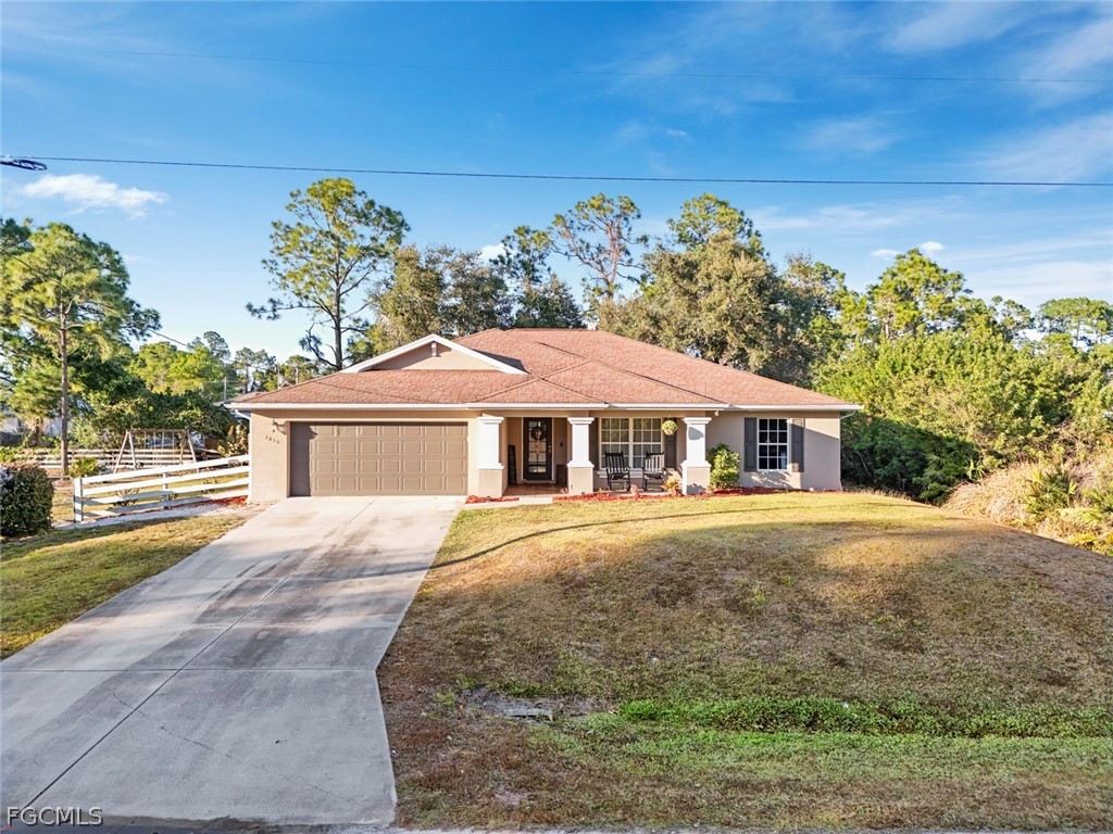 3610 65th Street West Lehigh Acres, FL 33971 - Photo 1 of 33 a front view of a house with a yard