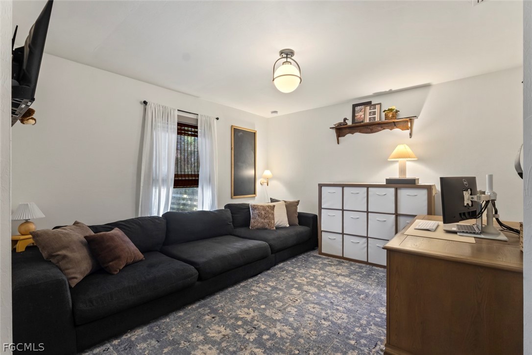3610 65th Street West Lehigh Acres, FL 33971 - Photo 22 of 33 a living room with furniture and a flat screen tv